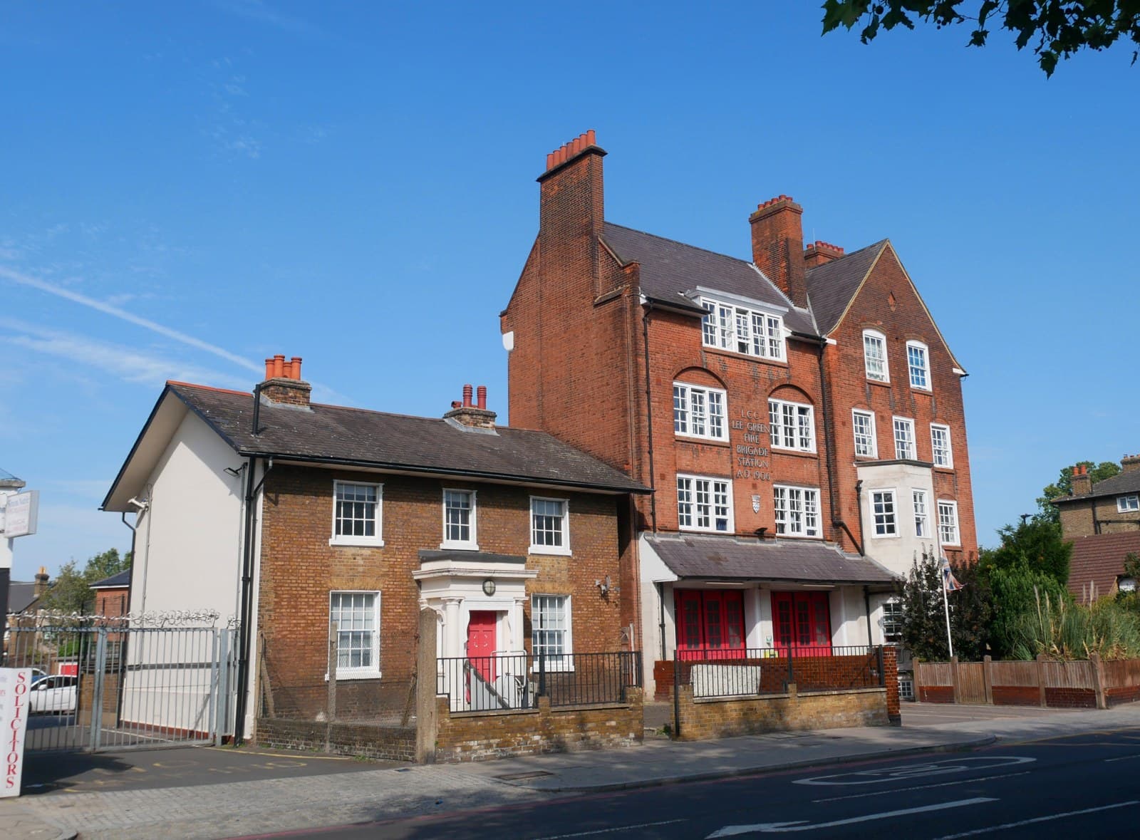 Brick buildings along Eltham Road at Lee Green, southeast London, including the former Lee Green Fire Station, under a clear blue sky, Aug. 11, 2025. Illustrative image of the neighborhood near the junction where the fuel giveaway took place, not of London's Batman or the event. Photo: Doyle of London, CC BY-SA 4.0, via Wikimedia Commons. Source page: https://commons.wikimedia.org/wiki/File:7_Eltham_Road_and_the_Lee_Green_Fire_Station_(01).jpg