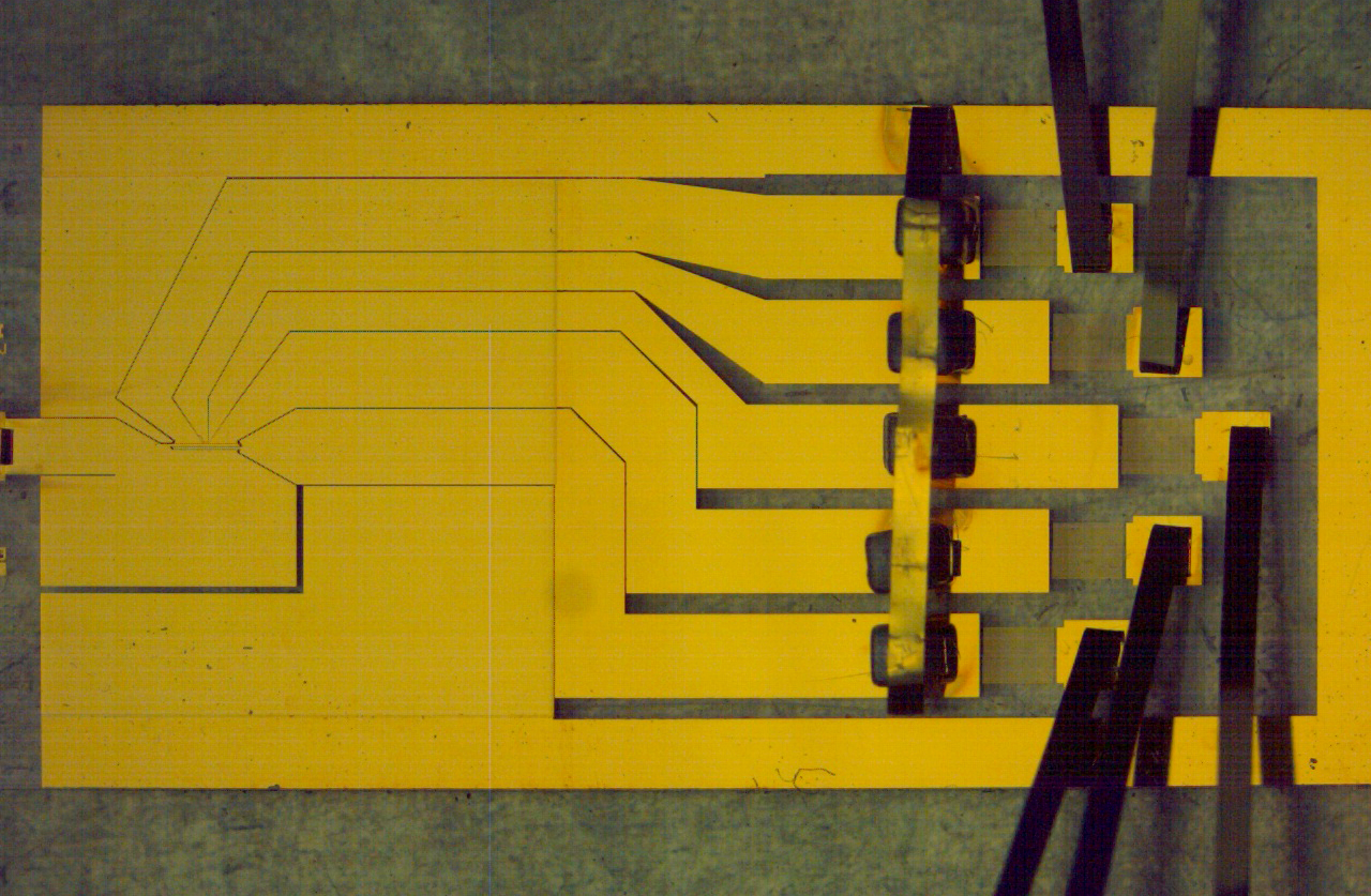 A flat chip patterned with gold electrodes used to confine ions above its surface.